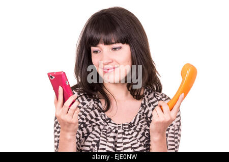 Belle jeune femme à l'aide d'orange et rétro mobile téléphone Banque D'Images