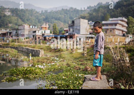 Un enfant à la pêche dans l'morningin Pokhara, Népal Banque D'Images