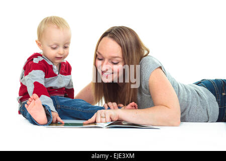Smiling Mother and Baby Boy Reading Book Together isolées sur fond blanc Banque D'Images