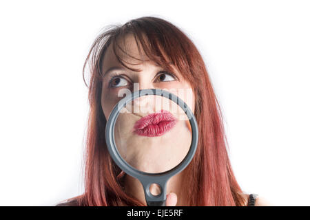 Femme avec une loupe en face de bouche Banque D'Images