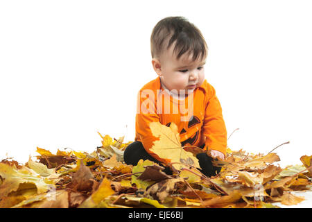 Sweet laughing baby fille jouant avec une énorme citrouille citrouille portant un chapeau tricoté sur fond blanc Banque D'Images