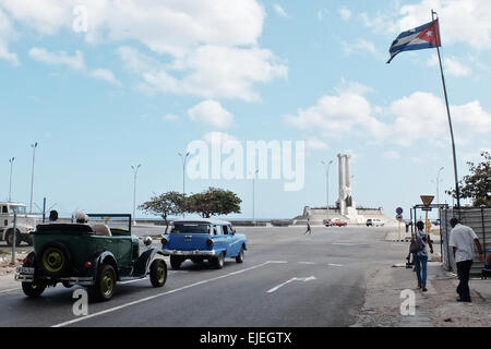 Les conducteurs de voitures américaines classiques vers le monument aux victimes de l'USS Maine, construit en 1926, dans sur le Boulevard Malecon de La Havane, en l'honneur de 260 marins américains qui ont perdu la vie dans l'explosion de l'USS Maine le 15 février 1898 dans le port de La Havane. Le naufrage du Maine et de l'indignation des États-Unis sur l'Espagne la répression brutale de la rébellion cubaine ont conduit à l'éclatement de la guerre hispano-américaine en avril 1898. Banque D'Images