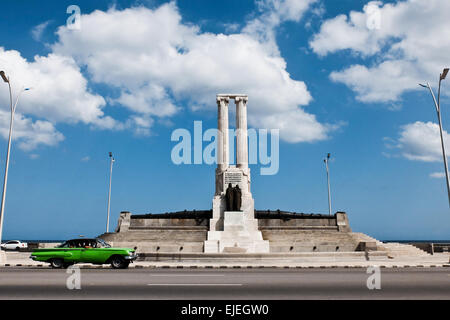 American Vintage voitures passent le Monument aux victimes de l'USS Maine, construit en 1926, dans sur le Boulevard Malecon de La Havane, en l'honneur de 260 marins américains qui ont perdu la vie dans l'explosion de l'USS Maine le 15 février 1898 dans le port de La Havane. Le naufrage du Maine et de l'indignation des États-Unis sur l'Espagne la répression brutale de la rébellion cubaine ont conduit à l'éclatement de la guerre hispano-américaine en avril 1898. Banque D'Images