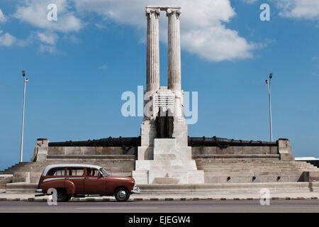 American Vintage voitures passent le Monument aux victimes de l'USS Maine, construit en 1926, dans sur le Boulevard Malecon de La Havane, en l'honneur de 260 marins américains qui ont perdu la vie dans l'explosion de l'USS Maine le 15 février 1898 dans le port de La Havane. Le naufrage du Maine et de l'indignation des États-Unis sur l'Espagne la répression brutale de la rébellion cubaine ont conduit à l'éclatement de la guerre hispano-américaine en avril 1898. Banque D'Images