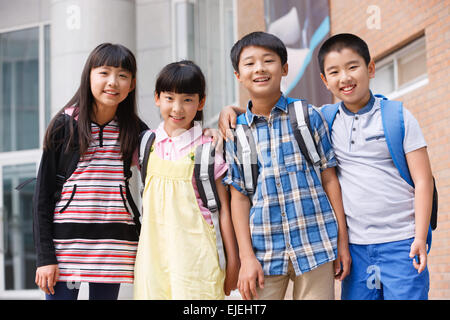 Le mignon petit élève à l'école autour de l'épaule du bras Banque D'Images