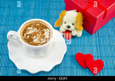 Café Artisan dans une tasse blanche décorée avec de la mousse. Fort présent rouge pour la Saint-Valentin, avec deux cœurs et un chiot ne Banque D'Images