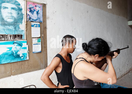 Une femme s'attaque à un champ de tir sous les yeux attentifs de Fidel Castro et Ernesto Che Guevara représenté sur les affiches, à La Habana Vieja ou la vieille Havane. Banque D'Images