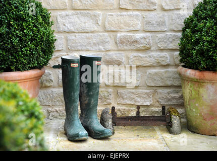 Fort en pot avec couvertures wellies par la porte d'une grange aménagée de Cotswold Banque D'Images