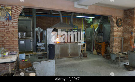 Un souffleur de verre sur l'île de Murano à Venise en utilisant des méthodes traditionnelles pour créer des sculptures en verre. Banque D'Images