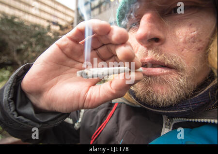 Un homme fumant une articulation en utilisant l'épice, un haut légal Banque D'Images
