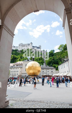 30 pieds de grand ballon jaune sculpture orb dans Kapitelplatz square avec en arrière-plan le château de Salzbourg Autriche Banque D'Images