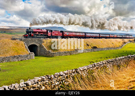 Régler, Yorkshire, UK. Mar 25, 2015. Train à vapeur spécial, la Pendle Dalesman, passe à Armoy Ribblesdale, près de régler, Yorkshire du Nord. La locomotive est 'Leander' un moteur de classe du Jubilé de l'ancien chemin de LMS. Banque D'Images