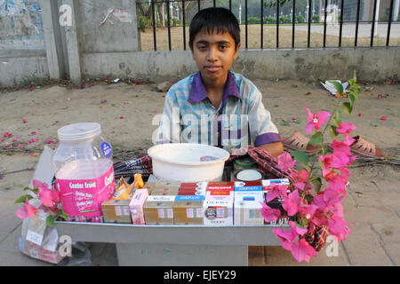 Dhaka, Bangladesh. Mar 25, 2015. Un vendeur de rue enfants bangladais attendre que les clients devant Bangbandhu Centre International de Conférences à Dhaka. Il vend la feuille de bétel et les cigarettes, le 25 mars 2015 Credit : Mamunur Rashid/Alamy Live News Banque D'Images