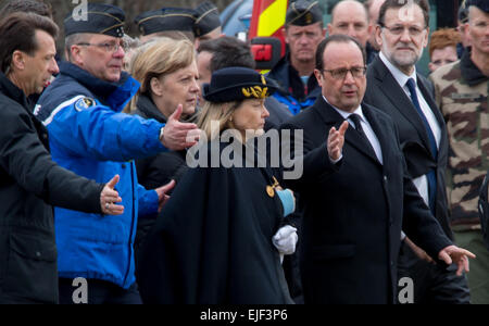 Seyne Les Alpes, France. Mar 25, 2015. Le président français, François Hollande, (L), l'Allemand Cancellor Angela Merkel (C) et le premier ministre Espagnol Mariano Rajoy (retour) sont accueillis à l'emplacement d'atterrissage temporaires après son arrivée sur un hélicoptère à Seyne Les Alpes, France, 25 mars 2015. Les politiciens a inspecté le site de l'accident où un vol Germanwings s'est écrasé le 24 mars. Photo : Peter Kneffel/dpa/Alamy Live News Banque D'Images