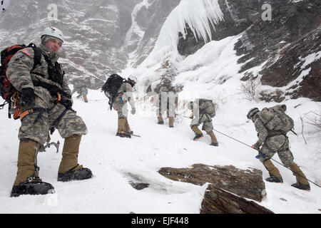 Le capitaine de l'armée américaine Jason Poutres, agent de la Division de la formation à l'École de guerre en montagne de l'armée à Jéricho, Vermont), observe l'encoche des contrebandiers d'escalade des soldats pendant leur phase finale du cours d'Alpinisme militaire de base à Jeffersonville, Vermont, le 19 février, 2015. Les étudiants du cours d'Alpinisme militaire de base passer deux semaines l'acquisition des compétences et connaissances nécessaires à l'utilisation en terrain montagneux. Photo de la Garde nationale américaine par Tech. Le Sgt. Sarah Mattison Banque D'Images