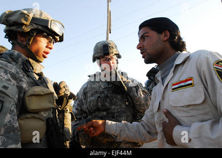 Le 1er centre Jessie Sheehan, chef de peloton d'infanterie de Knoxville, au Tennessee, attribuée à la société D, 1er Bataillon du 505th Parachute Infantry Regiment, rencontre avec un fils de l'Iraq au chef des forces de sécurité iraquiennes au cours d'un point de contrôle des inspections de contrôle tôt le matin avec son traducteur irakien, Daniel, 26 déc dans la communauté de Karb Gla du Rashid District. Les soldats du 1er "Panther" NE., 505th Parachute Inf. Regt., attaché à la 1ère Brigade Combat Team, 4e Division d'infanterie, Division Multinationale ñ Bagdad, a visité les forces de sécurité irakiennes occupant des postes de contrôle dans le sud de B Banque D'Images