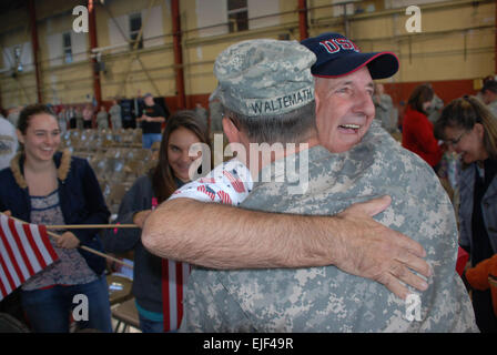 Morris Waltemath de Fort Wayne, Ind., étreintes, son fils le Lieutenant de la Garde nationale de l'Indiana Col Waltemath Ross, la 76e Brigade d'infanterie de l'agent du personnel de l'équipe de combat qui sont revenus de l'Irak Mercredi, 5 novembre 2008 comme Waltemath Ross's Daughters, Victoria, gauche et droite, Madison, regarder. Au cours du déploiement de la brigade, il a appuyé les missions de sécurité, missions de reconnaissance aérienne, de la présence de patrouilles, escortes de convoi, et des efforts de reconstruction de l'économie iraquienne. La brigade déploiement irakien a marqué le plus grand déploiement de la garde de l'Indiana depuis la Seconde Guerre mondiale. Banque D'Images