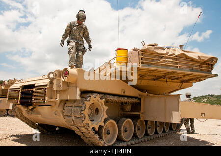 Le sergent de l'armée américaine. Christopher Dooley, de Leonardtown, Md., un réservoir gunner dans 2e Bataillon, 8e régiment de cavalerie, 1re Division de cavalerie, vérifie la boîte de batterie et les connexions sur son M1A1 Abrams tank après les qualifications du tir sur la gamme multi-usage Blackwell sur Fort Hood le 28 mai 2013. Le sergent major de l'Armée de Raymond F. Chandler III, lui-même ancien tanker, payé l'unité d'une visite plus tard dans la journée. L'Armée américaine par le Sgt. Ken cicatrice, Mobile 7e Détachement des affaires publiques Banque D'Images