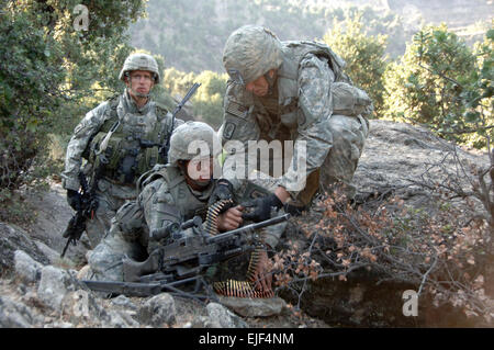 Le sergent de l'armée américaine. 1re classe Matthew Kahler, gauche, supervise et assure la sécurité de PFC. Jonathan Ayers et Adam Hamby tandis qu'ils disposer une mitrailleuse M240 dans le cadre d'une position de combat dans les montagnes de la province de Kunar en Afghanistan le 23 octobre, 2007. Les soldats sont tous à partir de la 2e Bataillon, 503e Parachute Infantry Regiment. Le s.. Justin Holley, de l'armée américaine. Banque D'Images