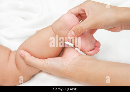 Mère working jambe et le muscle du pied de son bébé,touche de bonheur Banque D'Images