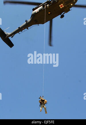 Le s.. Michael ien que par "Rronnie", son chien de travail militaire, 554th de Police militaire est hissé dans un UH-60 Blackhawk hélicoptère pendant une mission d'entraînement de levage-canin 15 juillet aérodrome près de Bagram, en Afghanistan. Photo de l'Armée américaine par la CPS. Aubree Rundle Banque D'Images