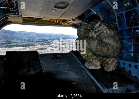 Le Sgt. Michael Cole, un hélicoptère CH-47 Chinook de mécanicien affecté à la Compagnie B, 2e Bataillon de soutien général, 36e Brigade d'aviation de combat, Task Force Falcon, numérise son espace aérien lors d'un mouvement de matériel mission July 17, 2010 l'air de Bagram, en Afghanistan. Banque D'Images