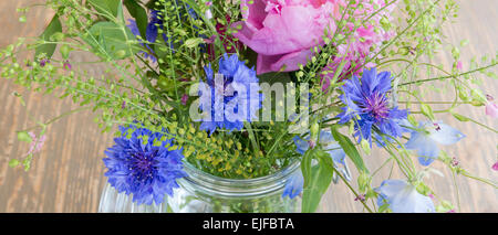 Posy bande d'assez intéressant rose pastel et bleu fleurs de printemps et d'été, un bouquet floral arrangement in glass vas Banque D'Images