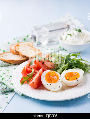 Le petit-déjeuner avec des oeufs à la coque, roquette, fromage et tomates, selective focus Banque D'Images