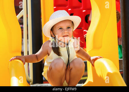 Portrait d'un bébé dans un chapeau blanc et un t-shirt jaune sur l'aire de jeux sur une journée ensoleillée. Profondeur de champ. L'accent sur le modèle. Banque D'Images