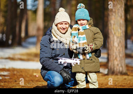 Père et fils Playing with toy airplane in forest Banque D'Images