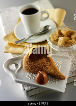 Une spécialité de pâtisserie faite à la main riche gâteau au café et au chocolat rempli de souris avec du café dans un cadre de table blanc Banque D'Images