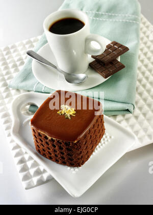 Une spécialité de pâtisserie faite à la main, des gâteaux au chocolat riches et délicieux avec du café dans un cadre de table blanc Banque D'Images