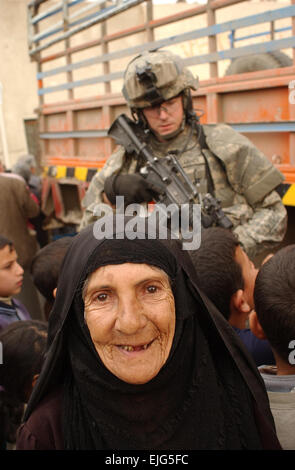 Une femme âgée sourit comme des soldats de l'Armée américaine à partir de la troupe, 4e Escadron, 9e régiment de cavalerie, 2e Brigade Combat Team, 1re Division de cavalerie la prestation de l'aide sur la rue Haïfa à Bagdad, l'Iraq, le 13 février 2007. La CPS. Olanrewaju Akinwunmi Banque D'Images