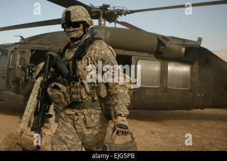 Un soldat sort un UH-60 Blackhawk hélicoptère dans le village de Darrah-I-Bum, province de Badghis, l'Afghanistan, le 5 janvier 2011. Le soldat faisait partie d'un cadre de l'accompagnement du personnel de la Force internationale d'assistance à la sécurité, le sergent sergent-major de commandement. Le major Marvin L. Hill lors d'une visite à la marine, les marins, soldats et d'opérations spéciales de l'Force-West vit et travaille à Darrah-I-Bum. U.S. Marine photo/Sgt. Brian Kester Banque D'Images