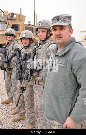 La commande de l'Armée de Sgt. Le major David Windham de la Garde nationale à Washington le 81e Brigade se tient avec ses citoyens-soldats à un pool de moteur sur la base aérienne de Balad, Iraq, Mars 1 cours d'une visite d'Air Force Le général Craig R. McKinley, chef de la Garde nationale et du Bureau de la commande de l'Armée de Sgt. Le major David Ray Hudson, chef de l'enrôle senior National Guard Bureau. Windham brigade de sécurité d'un convoi d'outre-mer de 1 100 soldats de la garde qui ont enregistré plus de 500 000 miles de la protection de convois de dispositifs explosifs de la chaussée et des embuscades. Le sergent-chef de l'Armée de l'air. Mike R. Smith, le Bureau de la Garde nationale Banque D'Images