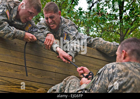 Des soldats américains en compétition dans l'Armée Warfighter, tenter de contester leur camarade tirer dessus, un mur de 15 pieds, à la course à obstacles sur deux jours, du défi, à Fort Leonard Wood, M.O., le 14 septembre 2010. La 14e édition du Défi pour les soldats des unités de police militaire apporte tout au long de l'armée afin de déterminer qui est le meilleur dans le domaine de la Police militaire. Benjamin Faske Banque D'Images