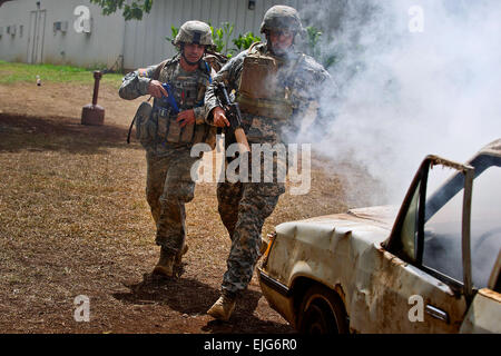 Le sergent de l'armée américaine. Tony Gonzalez et le sergent. Joseph Lollino, lutter contre les médecins affectés à la Compagnie Bravo, Tripler Army Medical Center, répondre à une simulation d'attaque du véhicule lors d'un traumatisme de combat dans le cadre de l'évaluation régionale du Pacifique 2012 Commande médicale meilleur concours infirmier le 28 août 2012, à Schofield Barracks, à Wahiawa, Hawaii. Le PRMC Meilleures Medic la concurrence est l'un des 72 heures d'essai physique et mentale des médecins de l'armée américaine le leadership, le travail d'équipe, des tactiques connaissances médicales et tâches. guerrier Les gagnants du concours PRMC passer à la concurrence pour le meilleur de l'Armée de Medic à Ft. Sam Houston Banque D'Images