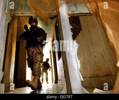 Les soldats de l'armée américaine recherchez une maison pendant une opération de bouclage et de frapper patrouille dans la partie nord de Nineva à Mossoul, en Irak, le 10 juillet 2006. Les soldats sont de 4e Peloton, la Compagnie Charlie, 2e Bataillon, 1e Régiment d'infanterie, 172e Stryker Brigade Combat Team basée à Fort Wainwright, Alaska. Tech. Le Sgt. Jeremy T. Lock. . Banque D'Images