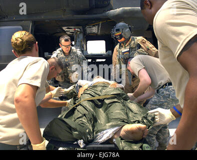 Un soldat de l'armée irakienne est déchargé d'une armée américaine Black Hawk UH-60A à la 47e Hôpital de Soutien au Combat à Mossoul, en Irak, le 20 juillet 2006. Le Black Hawk est l'équipage du 1er de l'avant, l'équipe médicale en charge de l'entreprise médicale 542nd Air Ambulance à Fort Campbell, Kentucky. Le soldat a subi une blessure par balle à la jambe. Le s.. Jacob N. Bailey. . Banque D'Images