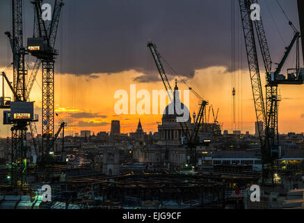 La silhouette du paysage urbain de grues sur le site de construction Lieu Bloomberg, London EC4, dans coucher de soleil avec la Cathédrale St Paul Banque D'Images