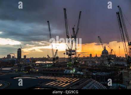 La silhouette du paysage urbain de grues sur le site de construction Lieu Bloomberg, London EC4, dans coucher de soleil avec la Cathédrale St Paul Banque D'Images
