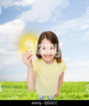 Smiling little girl holding Light bulb Banque D'Images