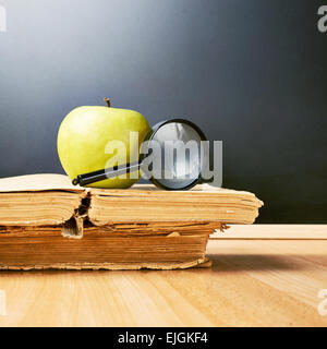 Apple et loupe sur les livres Banque D'Images