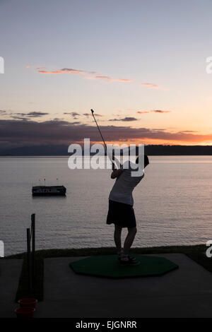 Un jeune homme d'essayer le trou d'un challange à Taupo, Nouvelle-Zélande. Banque D'Images