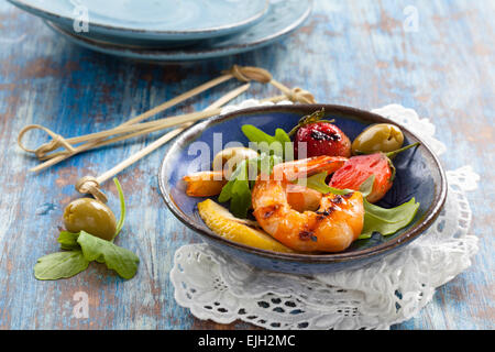 Salade avec crevettes, olives vertes, roquette, grillé fraises et citron. Banque D'Images