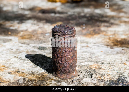 Old rusted broken steel bolt bloqué en surface du rocher. Banque D'Images
