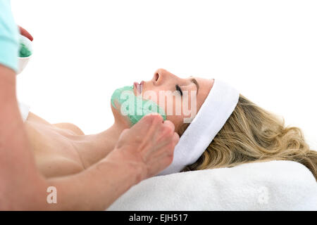 Offre d'appliquer le masque facial sur belle femme. Offre d'appliquer le masque facial thalasso vert sur la joue d'une ponte et Banque D'Images