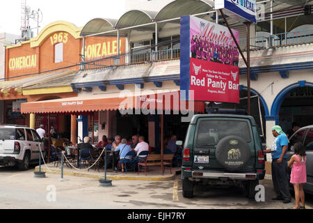 Jeune fille se en regardant son père se laver et cirer un mini van de touristes à l'extérieur de la culotte rouge Bar à Nuevo Progreso. Banque D'Images