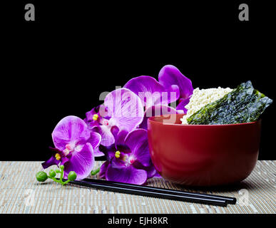 Saimin avec nouilles orientales d'algue Nori japonais et baguettes avec orchidée fleur hawaïenne isolé sur fond noir Banque D'Images