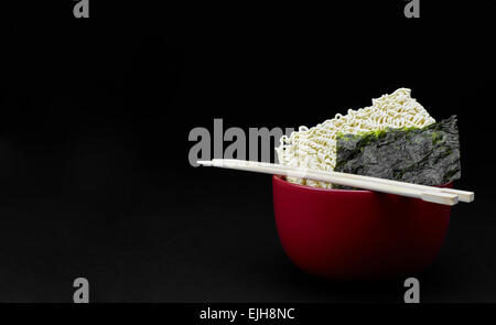 Saimin avec nouilles orientales d'algue Nori japonais et baguettes isolé sur fond noir Banque D'Images